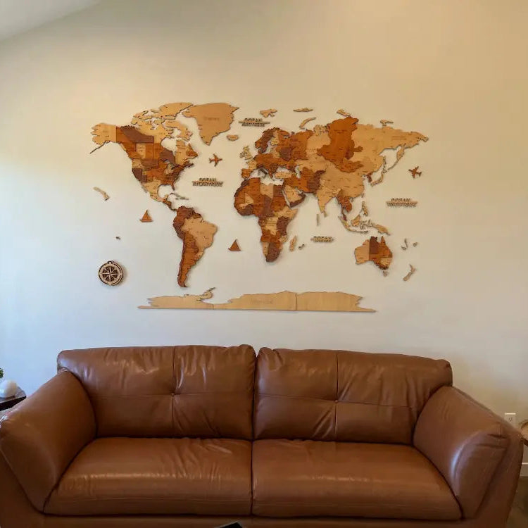 Carte du monde murale en bois installée au-dessus d’un canapé