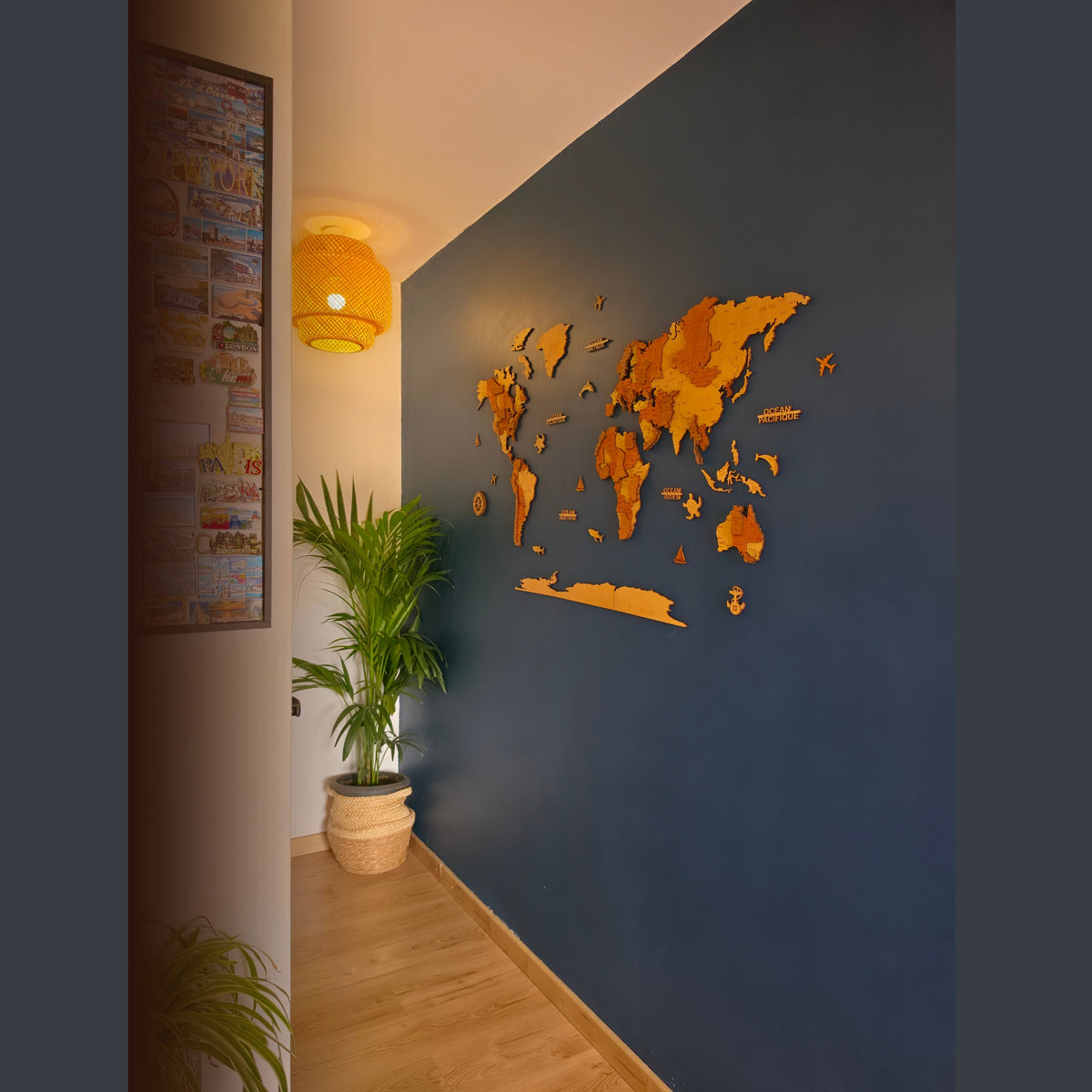 Carte du monde murale en bois installée au-dessus d’un canapé